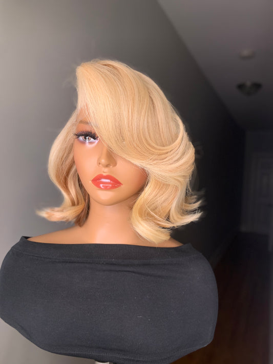 A mannequin head featuring a blonde wig with a straight/body-wave texture, wearing a black top.