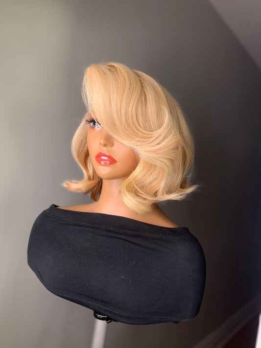 A mannequin head featuring a blonde wig with a straight/body-wave texture, wearing a black top.